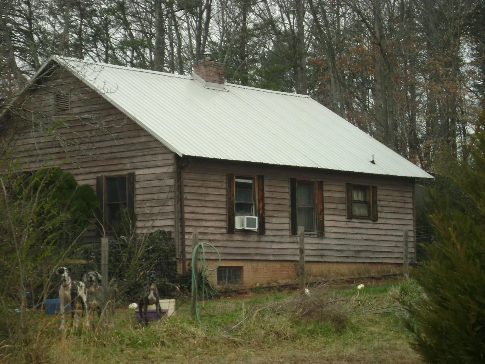 White metal roof on an old wood sided farmhouse, from a Asphalt Shingle Roof Repair job in Temple